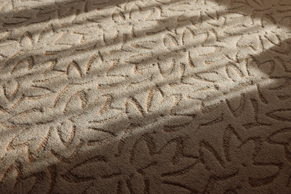 Close-up of a residential carpet being vacuumed with a modern, upright vacuum cleaner by Merton Carpet Cleaners, featuring a clear dust container filled with dust and debris, attached to a flexible, p